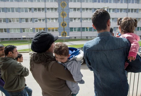 Eine Fl&uuml;chtlingsfamilie vor einem Fl&uuml;chtlingsheim