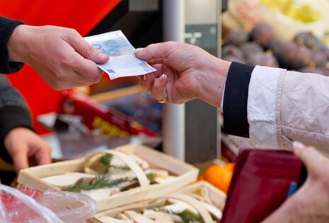 Eine Hand übergibt einen 20-Euro Schein