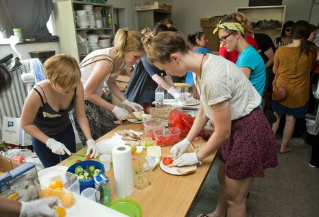 Mehrere ehrenamtliche Helfer bereiten Essen zu