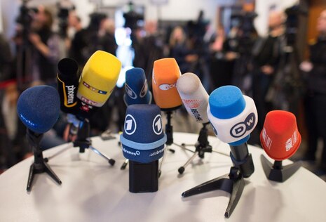 Verschiedene Mikrofone stehen auf einem Tisch.