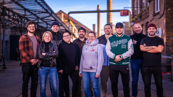 Männer und Frauen stehen nebeneinander.
